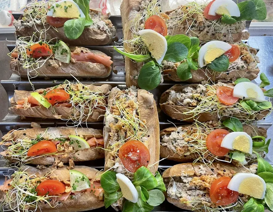 Sandwichs frais : germes de soja, tomate, œuf, mâche, alignés sur une planche.